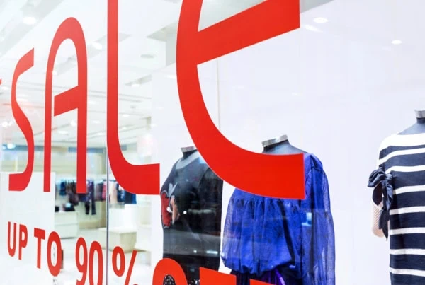 a very close up sale sign in a retail clothing store.