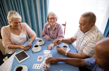 seniors play cards in a senior housing facility.