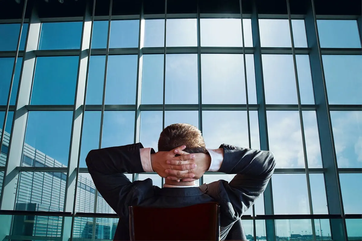 a businessman leans back in his chair and relaxes.