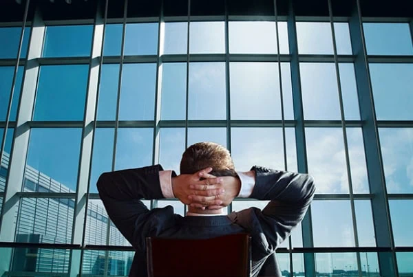 a businessman leans back in his chair and relaxes.