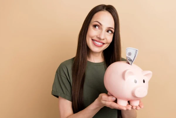 woman holding a piggy bank smiling