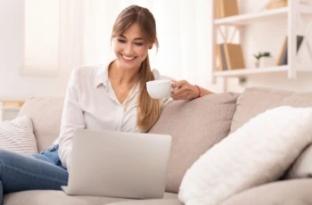 woman working on laptop smiling with coffee 1200