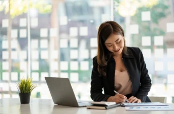 woman working at desk with charts calculator and pen