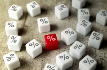 several white dice with percent signs on them and one red die with a percent sign that stands out.