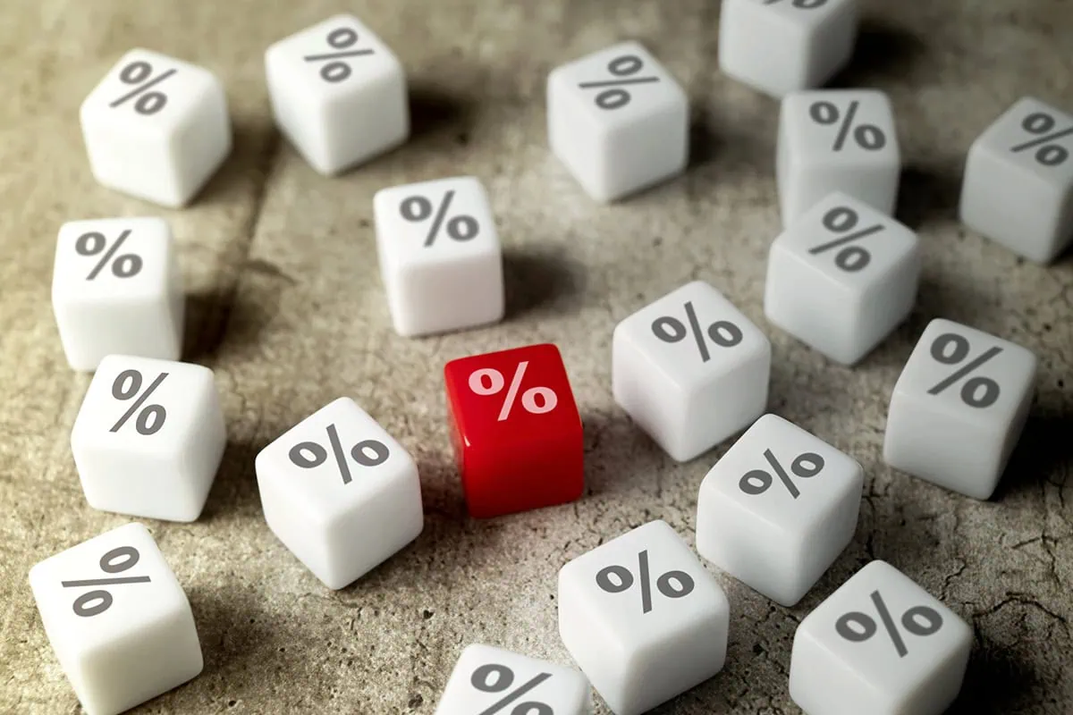 10 Dividend Stocks That Pay You Every Month (And Yield Up to 14.6%) 10 several white dice with percent signs on them and one red die with a percent sign that stands out.