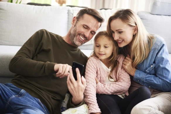 young family looking at finances on phone