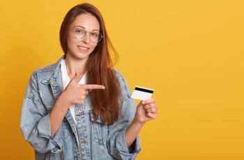 young teen with debit credit card yellow background