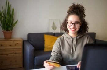 young woman credit debit card smartphone glasses 1200